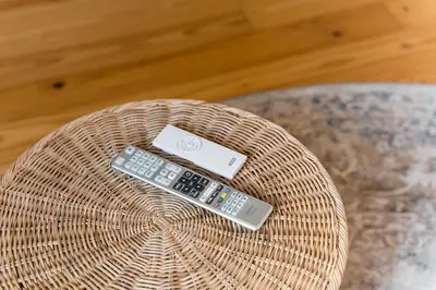 two remote controls sitting on top of a wicker table at GuestReady - Spacious and modern Apt W/ Skylight in Porto