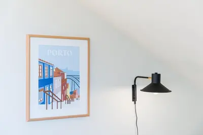 a picture hanging on a wall next to a lamp at GuestReady - Spacious and modern Apt W/ Skylight in Porto
