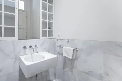 a white bathroom with a sink and a mirror at GuestReady - Bright Apartment near Bolhão in Porto