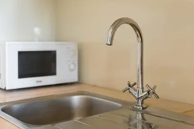 a kitchen counter with a sink and a microwave at GuestReady - Bright Apartment near Bolhão in Porto