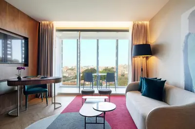 a room with a table and chairs and a large window at Renaissance Porto Lapa Hotel in Porto