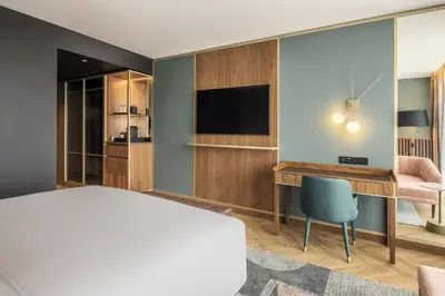 a hotel room with two beds and a flat screen tv at Renaissance Porto Lapa Hotel in Porto