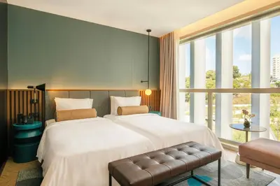 a hotel room with a bed and a desk and a window at Renaissance Porto Lapa Hotel in Porto