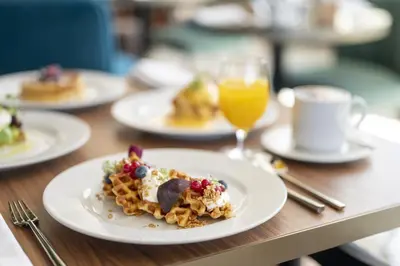 a table topped with plates of food and drinks at Renaissance Porto Lapa Hotel in Porto