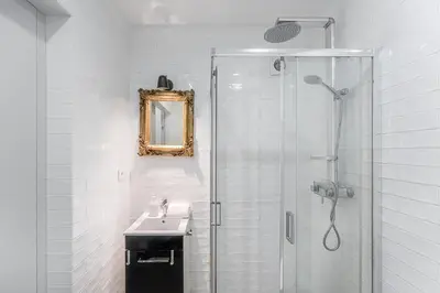 a white bathroom with a sink and a shower at GuestReady - Grayscale in Porto