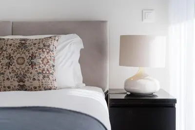 a bed with a pillow and a lamp on a nightstand at GuestReady - Ideal stay near Estádio do Dragão in Porto