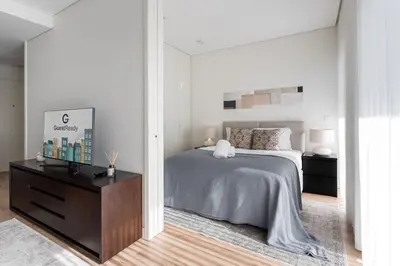 a white bedroom with a bed and a dresser at GuestReady - Ideal stay near Estádio do Dragão in Porto