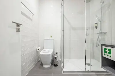 a white bathroom with a shower and a toilet at Lovely Balcony Porto Downtown in Porto