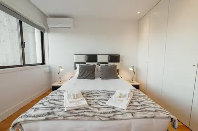 a bedroom with a large bed with two books on it at Downtown Stylish Apartment With Garage by Vacationy in Porto