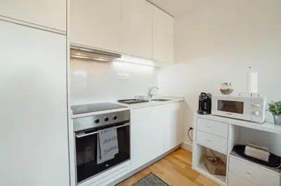 a white kitchen with a stove and a microwave at Downtown Stylish Apartment With Garage by Vacationy in Porto
