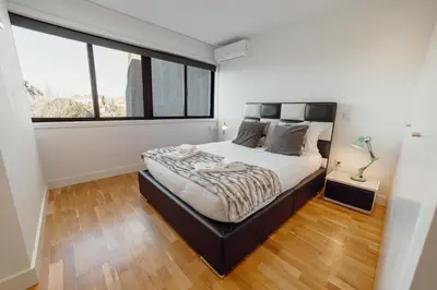 a bedroom with a bed and a large window at Downtown Stylish Apartment With Garage by Vacationy in Porto