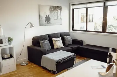 a living room with a black couch and a window at Downtown Stylish Apartment With Garage by Vacationy in Porto
