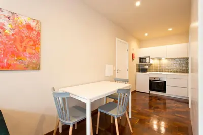 a kitchen and dining room with a white table and chairs at Aposentus - Your home in Porto in Porto