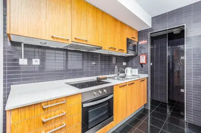 a kitchen with wooden cabinets and a sink at Dream On - Clérigos Lofts in Porto