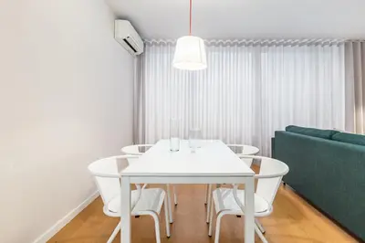 a white dining room with a white table and chairs at Dream On - Clérigos Lofts in Porto