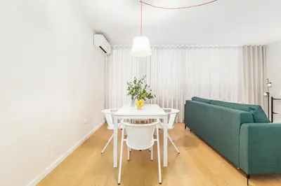 a living room with a white table and a green couch at Dream On - Clérigos Lofts in Porto
