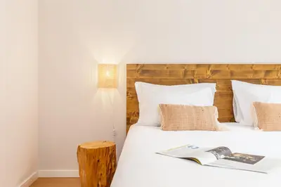 a bed with white sheets and a book on it at Dream On - Clérigos Lofts in Porto