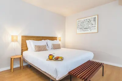 a bedroom with a bed with a plate of food on it at Dream On - Clérigos Lofts in Porto