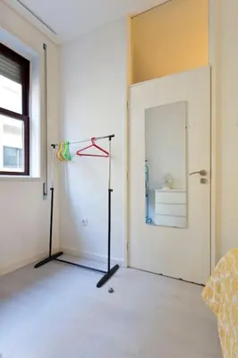 a room with a white door and a mirror at Aposentus - Breiner Apartment in Porto