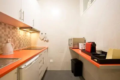 a kitchen with an orange counter top and a sink at Aposentus - Breiner Apartment in Porto