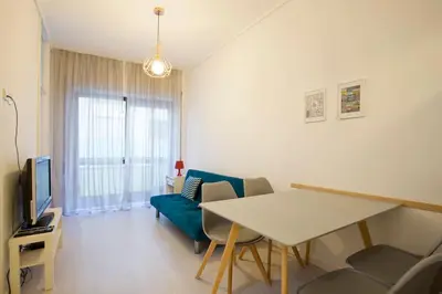 a living room with a table and a blue couch at Aposentus - Breiner Apartment in Porto