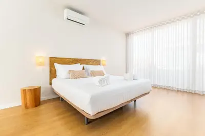 a white bedroom with a large bed and a window at Dream On - Almada Lofts in Porto