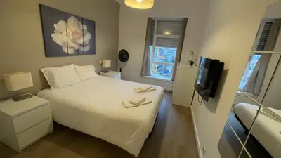 a small bedroom with a bed and a flat screen tv at HEART OF THE CITY 2! in Vila Nova de Gaia