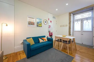 a living room with a blue couch and a table at Casa Barros - Trindade in Porto