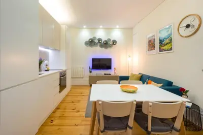 a kitchen and a living room with a table and chairs at Casa Barros - Trindade in Porto