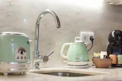 a kitchen sink with a tea kettle and a mixer at Casa Barros - Miragaia in Porto