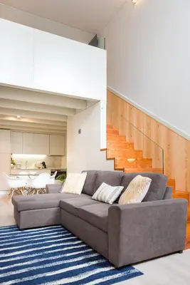 a living room with a couch and a staircase at Casa Barros - Miragaia in Porto