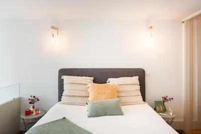 a bedroom with a bed with white sheets and pillows at Casa Barros - Miragaia in Porto