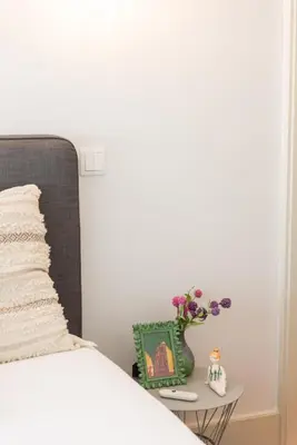 a bedroom with a bed and a table with a vase of flowers at Casa Barros - Miragaia in Porto