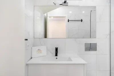 a white bathroom with a sink and a mirror at WHome Porto City Center Comfort & Stylishly Furnished in Porto