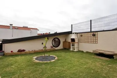 a small tree in a yard next to a house at Urban Cabin in Vila Nova de Gaia
