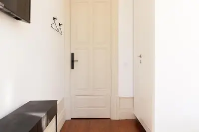 a hallway with a white door and a wooden floor at VIVA Alameda Suites - River Guest House in Porto
