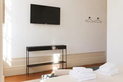 a living room with a tv and a couch at VIVA Alameda Suites - River Guest House in Porto