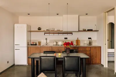 a kitchen with a table with chairs and a refrigerator at The Rebello Hotel & Spa - Small Luxury Hotels Of The World in Vila Nova de Gaia