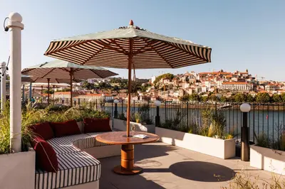 a patio with a table and an umbrella at The Rebello Hotel & Spa - Small Luxury Hotels Of The World in Vila Nova de Gaia