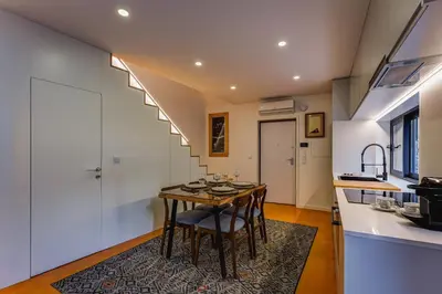 a kitchen and dining room with a table and chairs at Design Antas Home in Porto