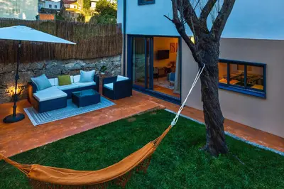 a hammock is tied to a tree in a yard at Design Antas Home in Porto