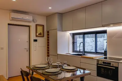 a kitchen with a table with plates and glasses on it at Design Antas Home in Porto