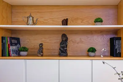 a shelf with books and statues on it at Design Antas Home in Porto