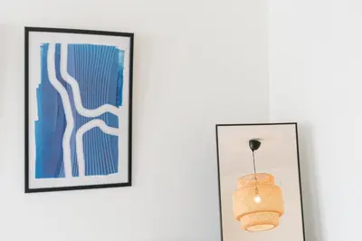 two framed pictures on a wall next to a light fixture at GuestReady - Almada 516 in Porto