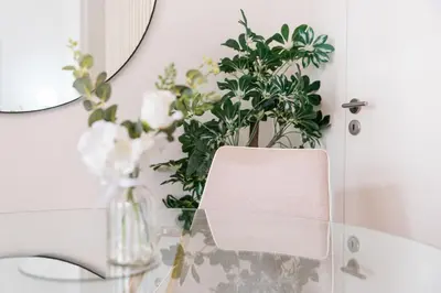 a vase of flowers sitting on a table next to a mirror at GuestReady - Almada 516 in Porto