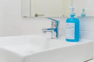a blue bottle of soap sitting on a bathroom sink at GuestReady - Almada 516 in Porto