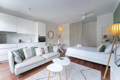 a white living room with a bed and a couch at GuestReady - Almada 516 in Porto