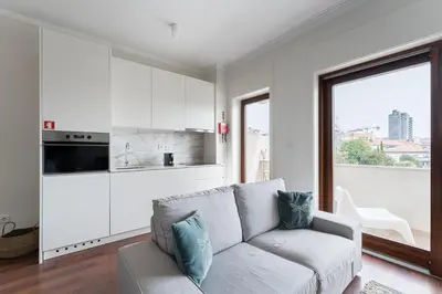 a living room with a couch and a kitchen at GuestReady - Almada 516 in Porto