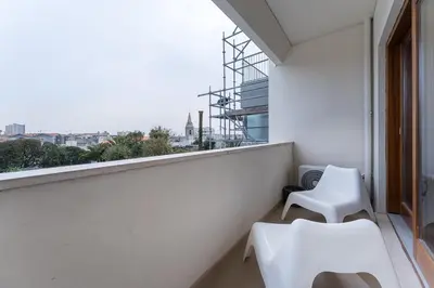 a balcony with two white chairs and a window at GuestReady - Almada 516 in Porto
