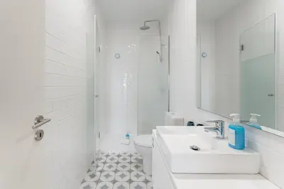 a white bathroom with a sink and a toilet at GuestReady - Almada 516 in Porto